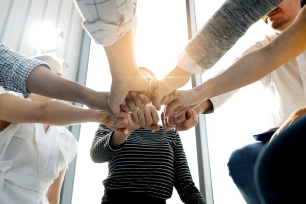 Close up top view of young and freshness energy business people putting their strong hands together. Stack of friendship hands. Unity and successful teamwork concept. Close up top view of young and freshness energy business people putting their strong hands together. Stack of friendship hands. Unity and successful teamwork concept.